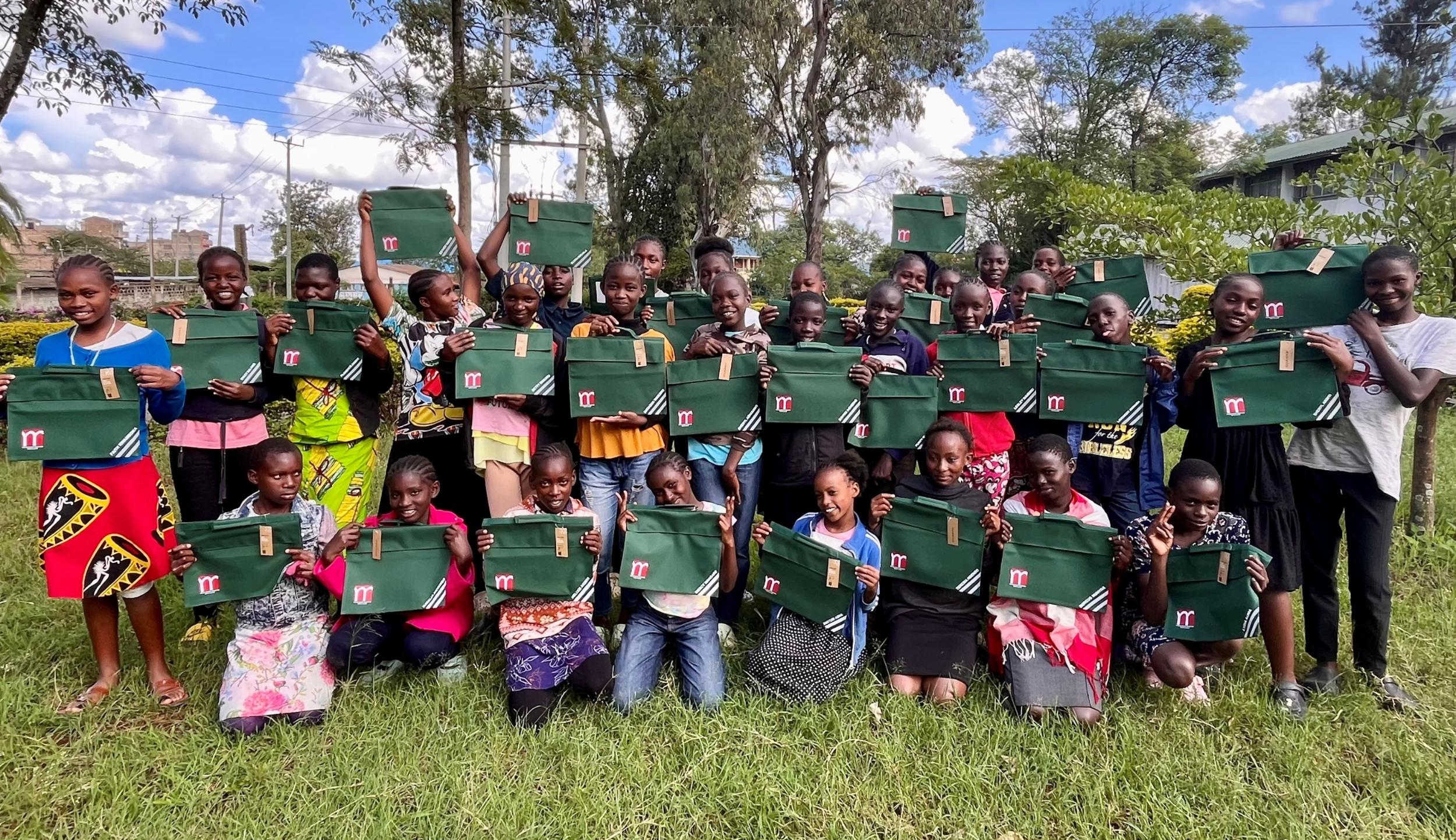 Stolz zeigen die Schülerinnen ihre neuen Schultaschen mit dem Münsterlogo