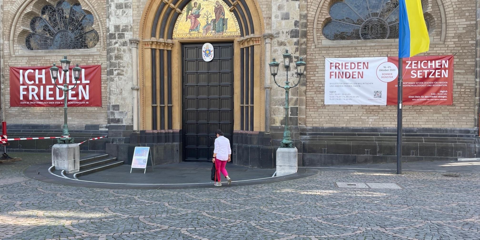 Am Hauptportal der Basilika werben Banner für das Stadtpatronefest im Oktober