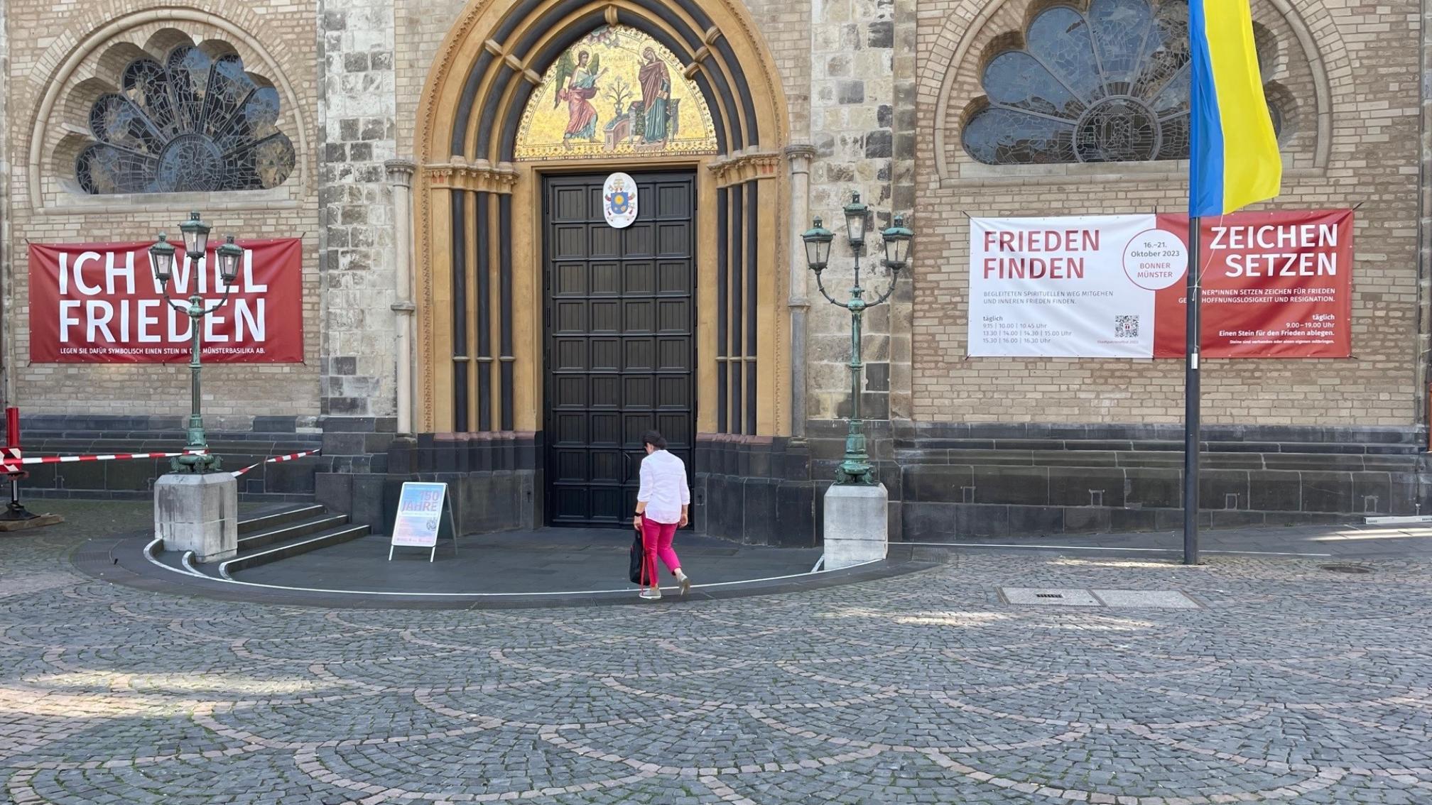Am Hauptportal der Basilika werben Banner für das Stadtpatronefest im Oktober
