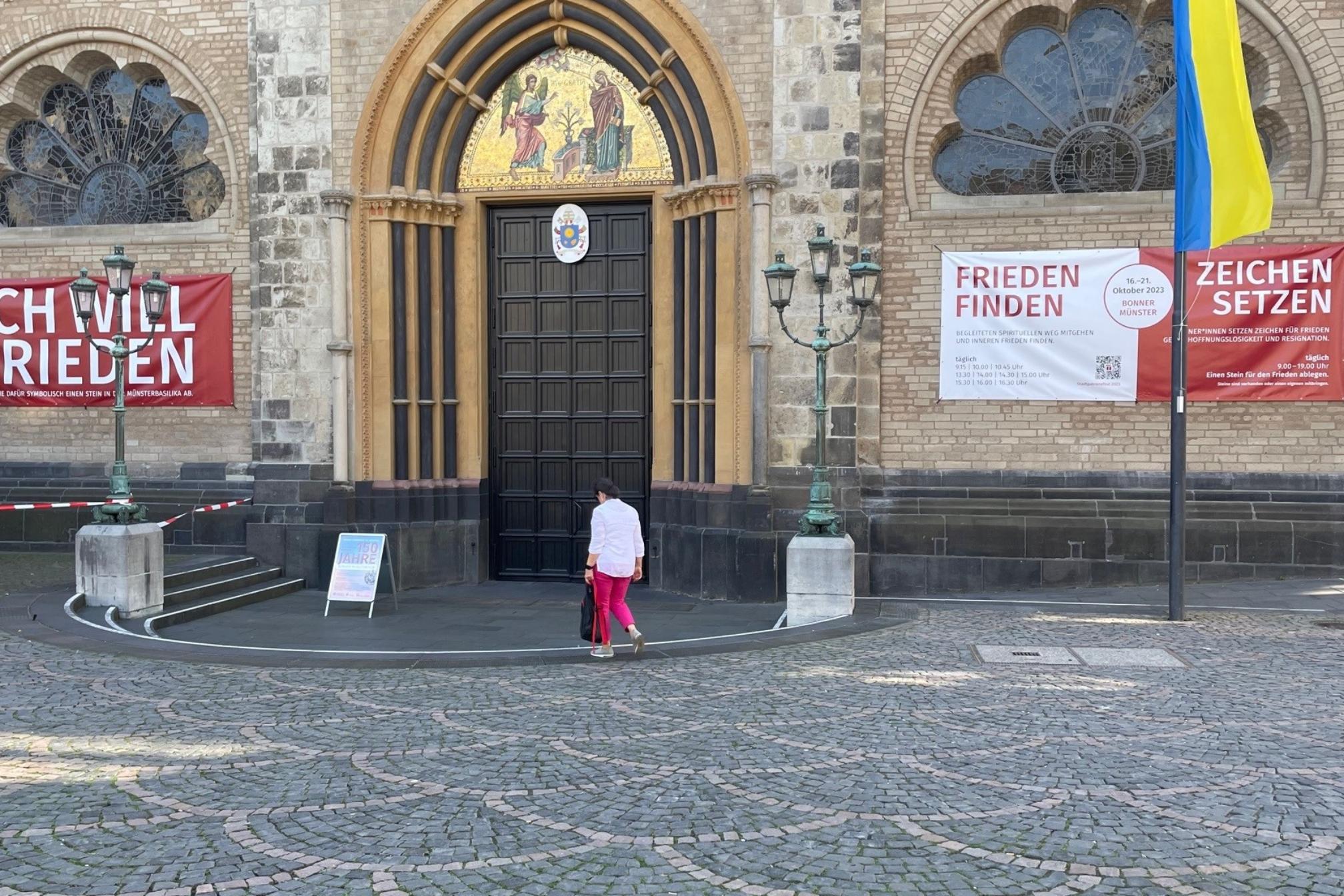 Am Hauptportal der Basilika werben Banner für das Stadtpatronefest im Oktober