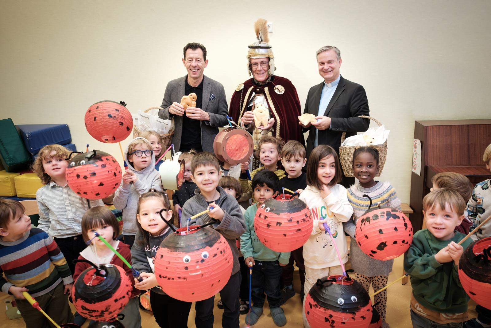 SWB-Kommunikationsleiter Jürgen Winterwerp, Dr. Christoph Rhein (St. Martin der Münstergemeinde) und Stadtdechant Msgr. Dr. Markus Hofmann (v.l.n.r.) überreichen Weckmänner an Kinder des katholischen Kindergartens St. Joseph.